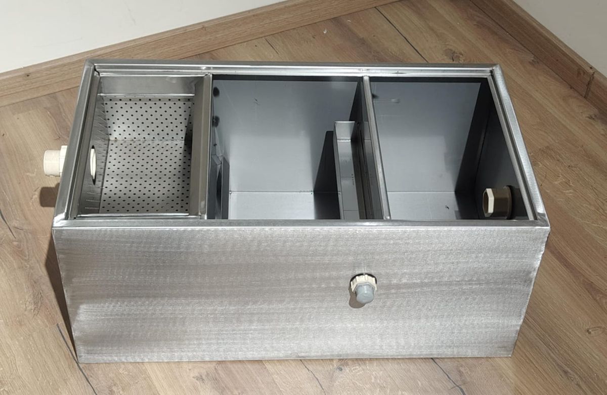 USP stainless steel grease trap with the lid removed, showing the perforated basket and baffle plates