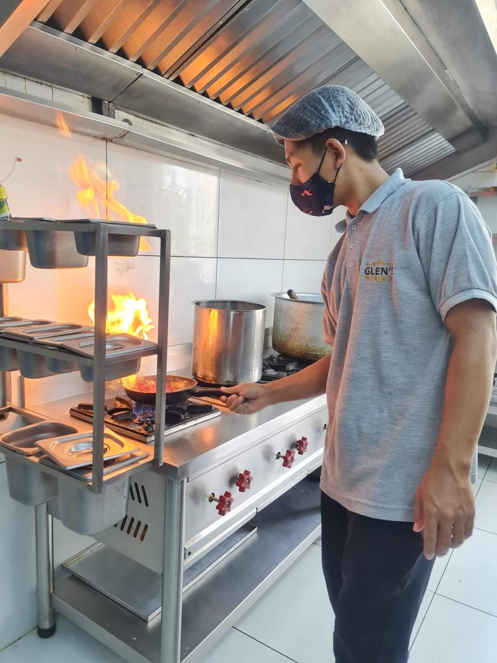 Chef cooking over a high-flame burner